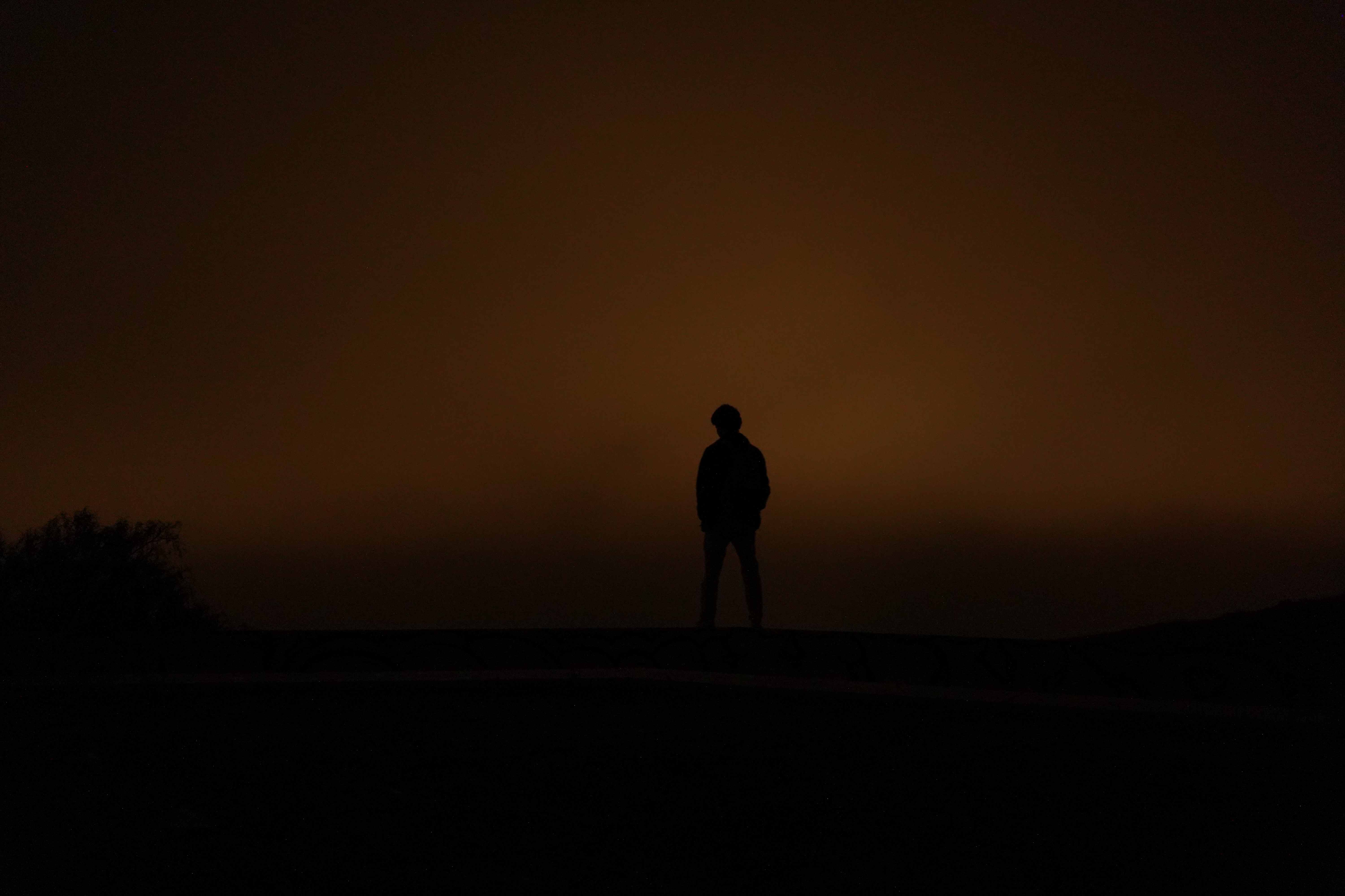 Creative study - Dramatic silhouette figure against golden sky at dusk